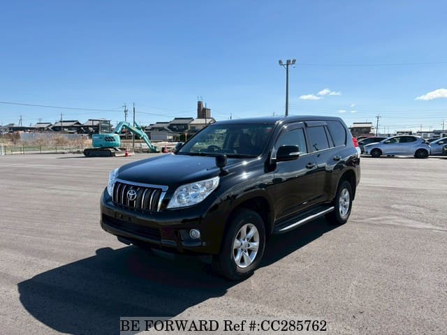 A grey sports car speeding down a highway at night.