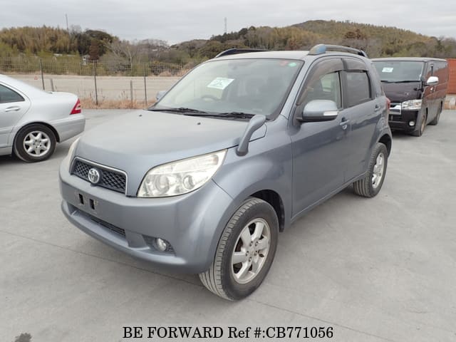A grey JDM sports car speeding down a highway at night.