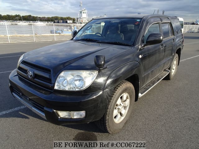 A grey sports car speeding down a highway at night.