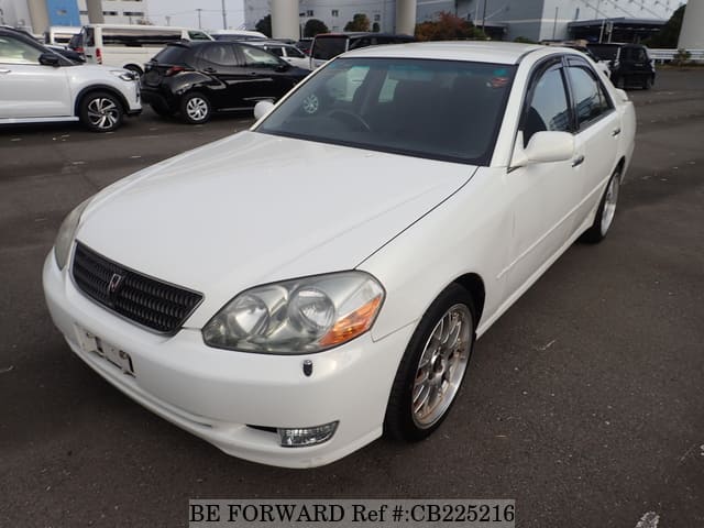 A grey JDM sports car speeding down a highway at night.