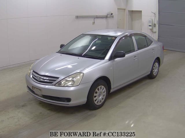 A grey sports car speeding down a highway at night.