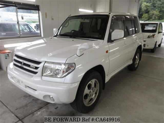 A grey JDM sports car speeding down a highway at night.