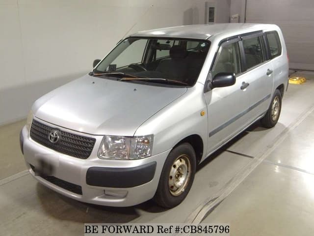 A grey JDM sports car speeding down a highway at night.