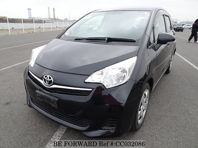 A grey sports car speeding down a highway at night.