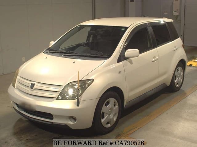 A grey JDM sports car speeding down a highway at night.