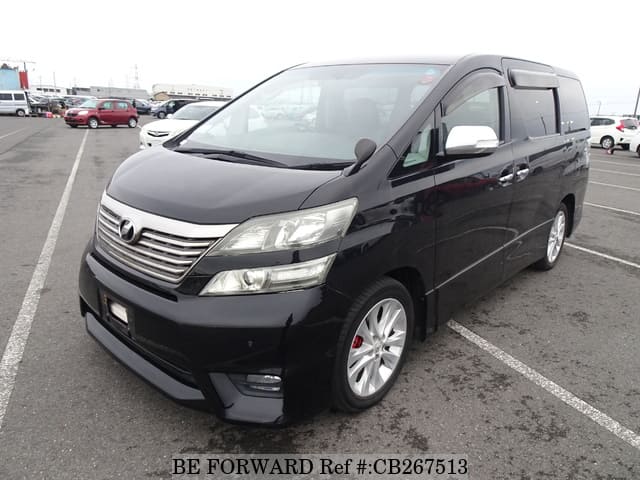 A grey JDM sports car speeding down a highway at night.