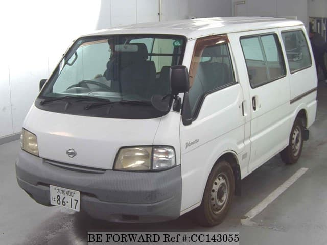A grey sports car speeding down a highway at night.