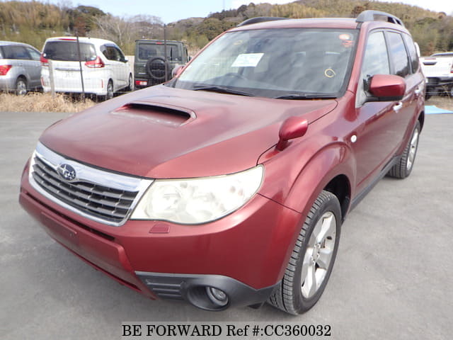 A grey sports car speeding down a highway at night.
