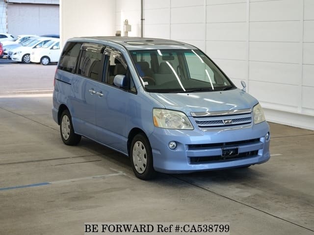 A grey JDM sports car speeding down a highway at night.