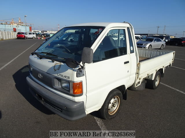 A grey JDM sports car speeding down a highway at night.