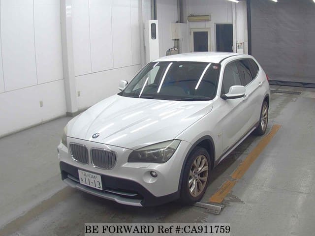 A grey sports car speeding down a highway at night.