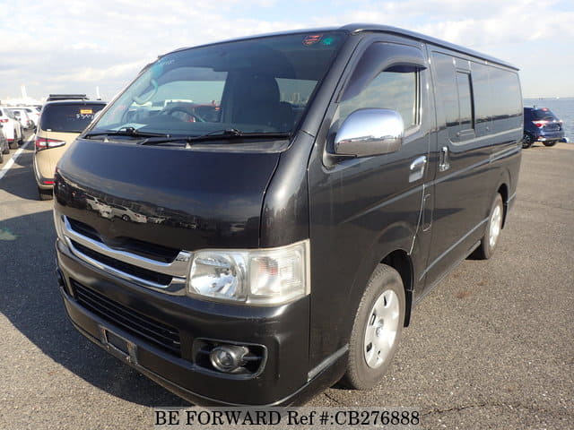 A grey JDM sports car speeding down a highway at night.