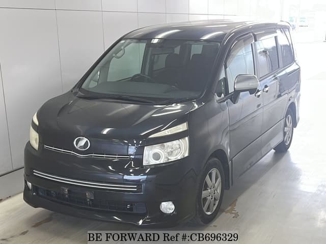 A grey JDM sports car speeding down a highway at night.