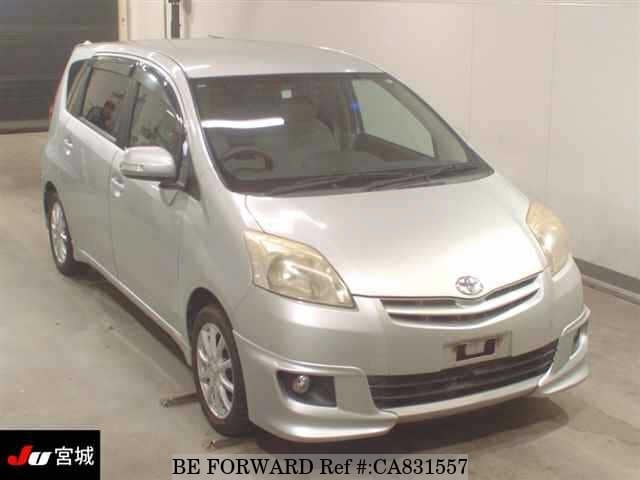 A grey JDM sports car speeding down a highway at night.