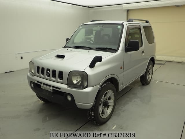 A grey JDM sports car speeding down a highway at night.