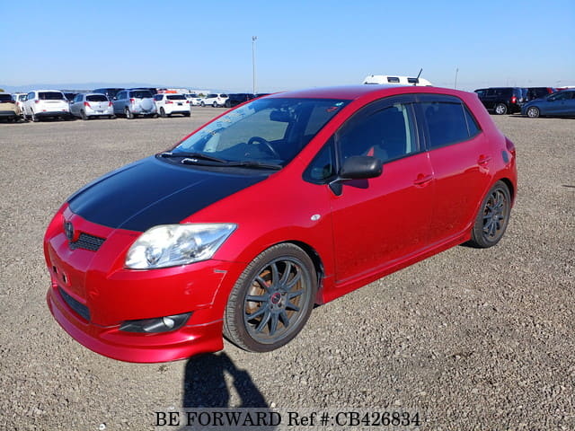 A grey JDM sports car speeding down a highway at night.