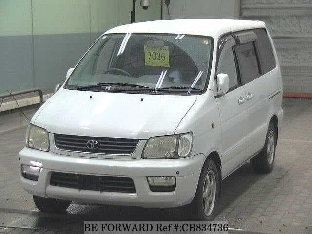 A grey JDM sports car speeding down a highway at night.