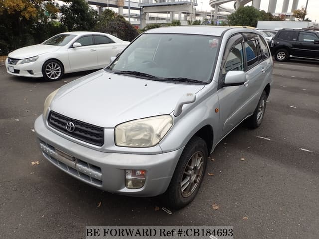 A grey JDM sports car speeding down a highway at night.