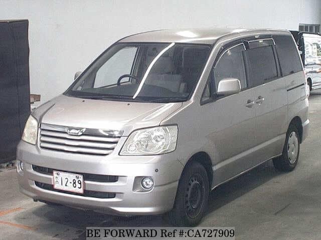 A grey JDM sports car speeding down a highway at night.