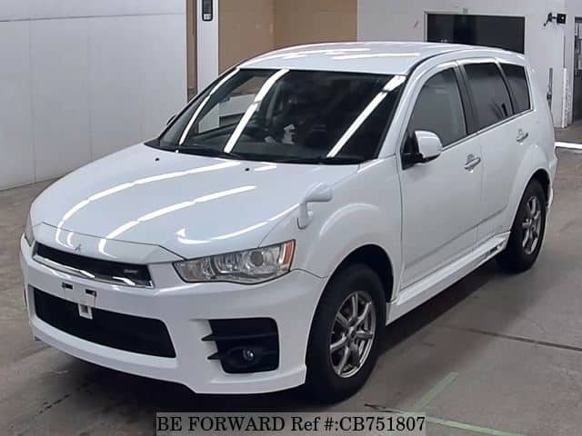 A grey JDM sports car speeding down a highway at night.