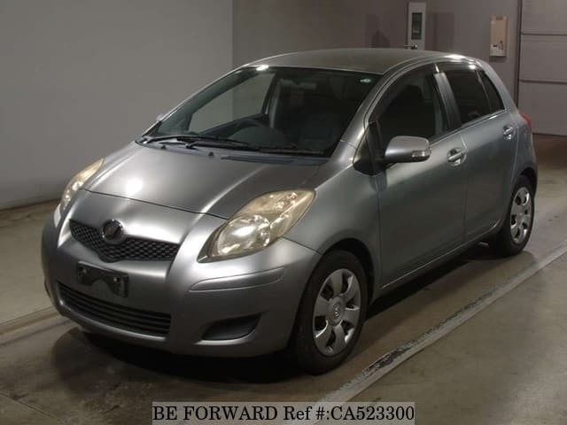 A grey JDM sports car speeding down a highway at night.