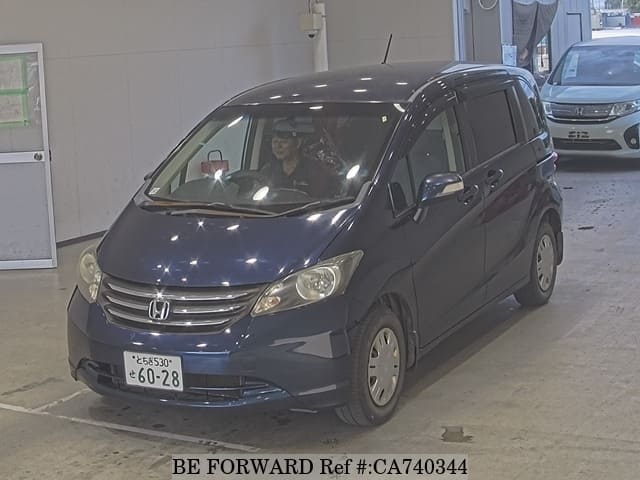 A grey JDM sports car speeding down a highway at night.