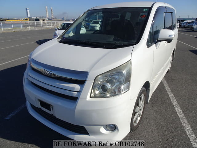 A grey JDM sports car speeding down a highway at night.