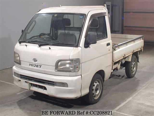 A grey sports car speeding down a highway at night.