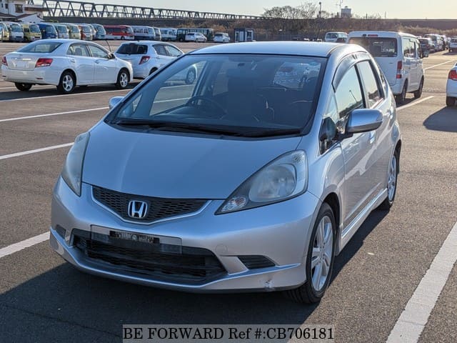 A grey JDM sports car speeding down a highway at night.