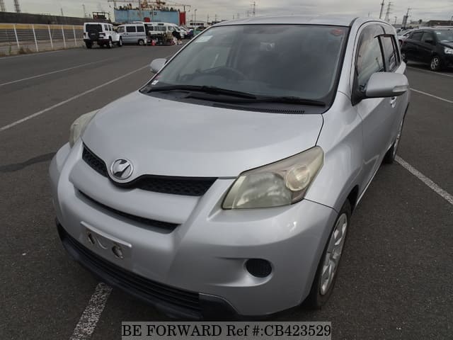 A grey JDM sports car speeding down a highway at night.