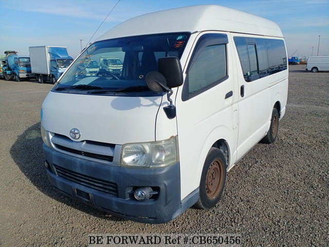 A grey sports car speeding down a highway at night.