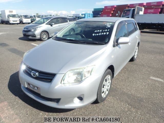 A grey JDM sports car speeding down a highway at night.