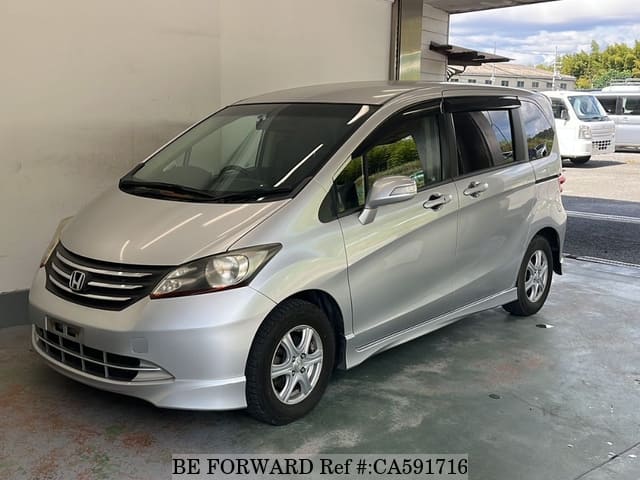 A grey JDM sports car speeding down a highway at night.