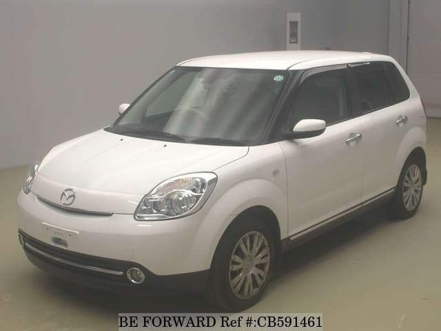 A grey sports car speeding down a highway at night.