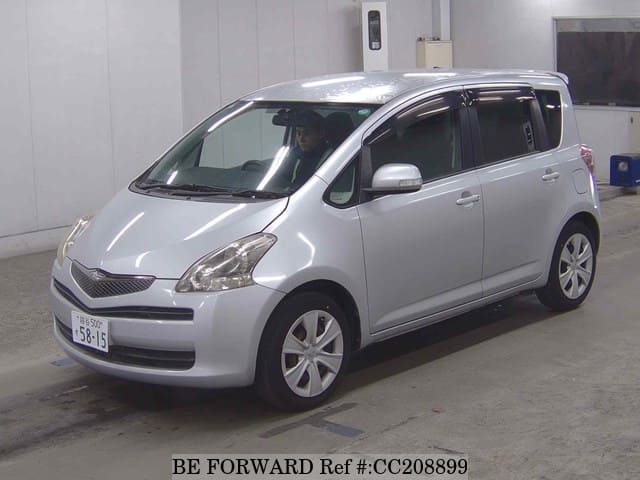 A grey sports car speeding down a highway at night.