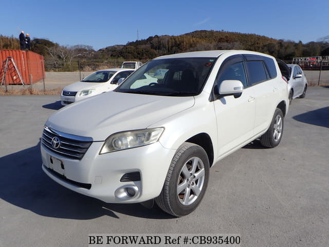 A grey sports car speeding down a highway at night.