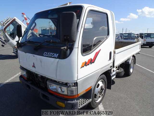 A grey JDM sports car speeding down a highway at night.