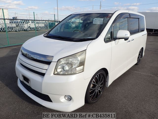 A grey JDM sports car speeding down a highway at night.