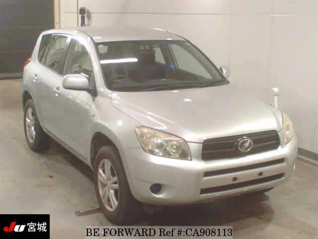 A grey sports car speeding down a highway at night.