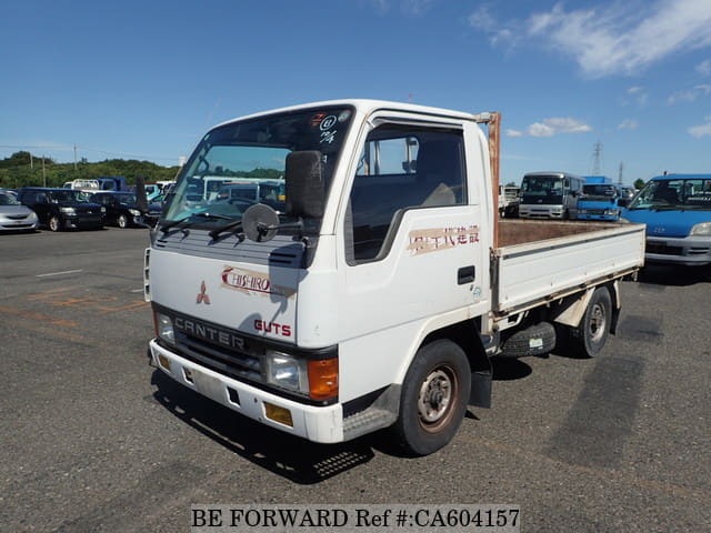 A grey JDM sports car speeding down a highway at night.