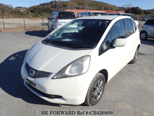 A grey JDM sports car speeding down a highway at night.