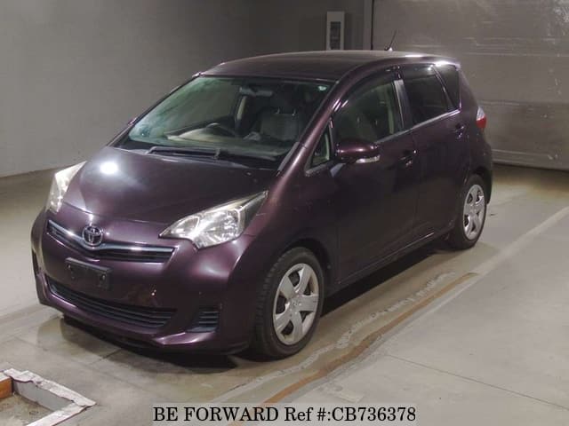 A grey JDM sports car speeding down a highway at night.