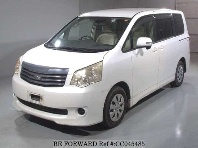 A grey sports car speeding down a highway at night.