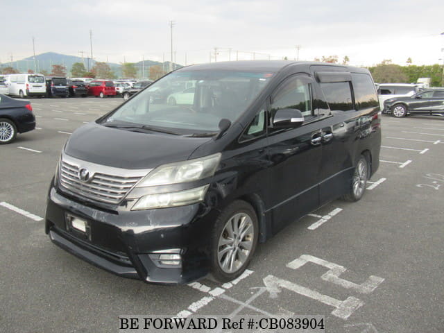 A grey sports car speeding down a highway at night.