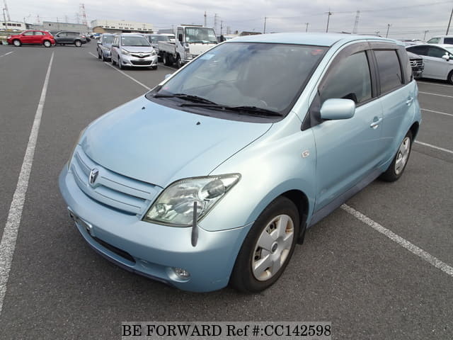 A grey sports car speeding down a highway at night.