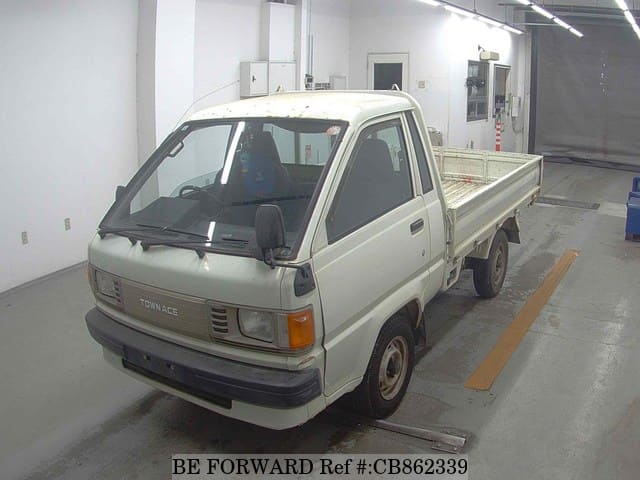 A grey JDM sports car speeding down a highway at night.