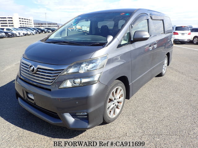 A grey JDM sports car speeding down a highway at night.