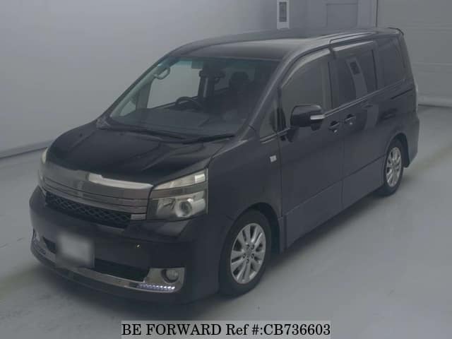 A grey JDM sports car speeding down a highway at night.