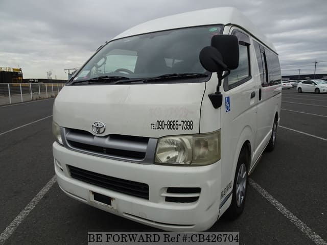 A grey sports car speeding down a highway at night.