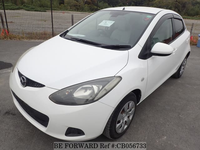 A grey sports car speeding down a highway at night.